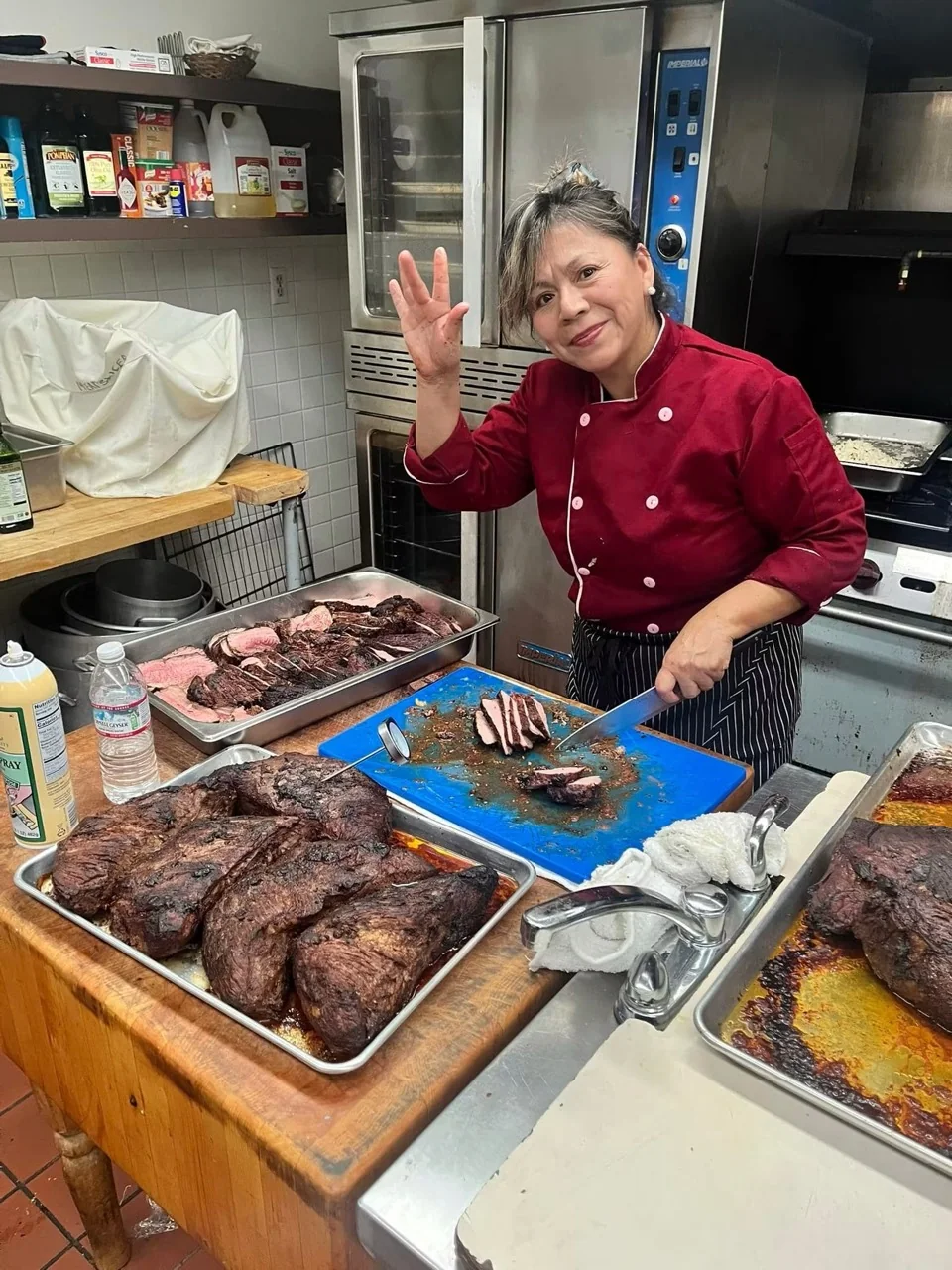 Founder and Executive Chef Patricia Montoya carving tri-tip in a catering kitchen
