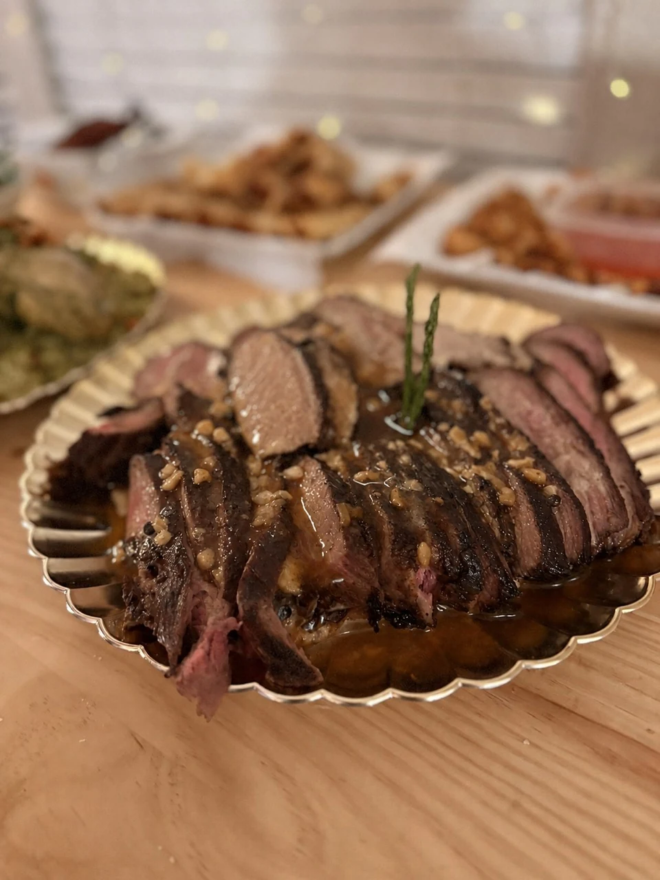 Sliced reverse-seared tri-tip served with mushroom sauce on a platter